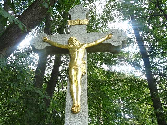 Kříž, po jehož stranách stojí sochy Panny Marie a Jana Evangelisty